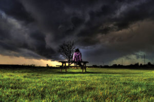 English weather idioms - girl on bench in front of storm